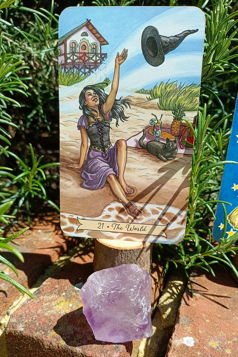 The World Tarot card from Everyday Witch with an amethyst chunk